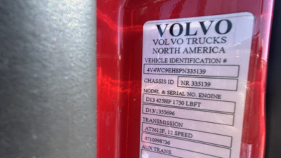 Volvo VNR64T300 truck badge on rear showing Vehicle Identification Number and model/engine details panel.
