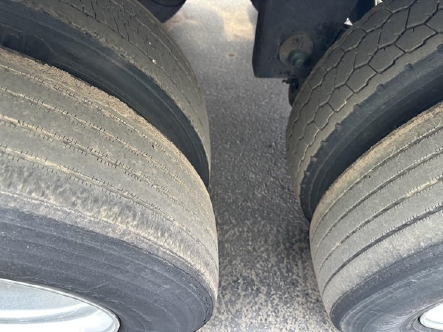 Trailer dual rear axles with worn tires and visible wheel wells showing tire treads.