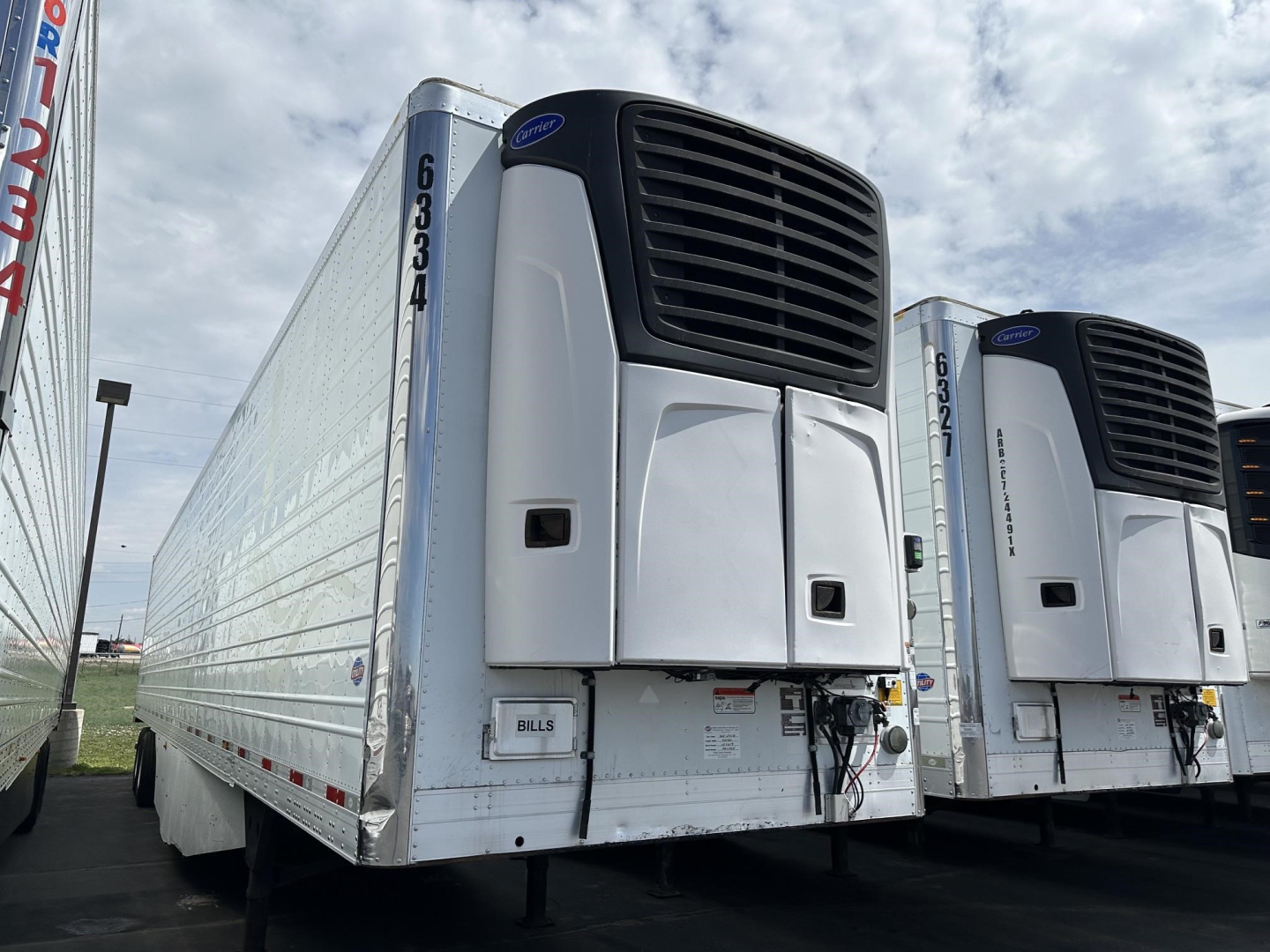 Trailer front left side of a 2015 Utility 3000R refrigerated trailer with large unit at front, VIN tag area, and horizontal cooling unit grilles.