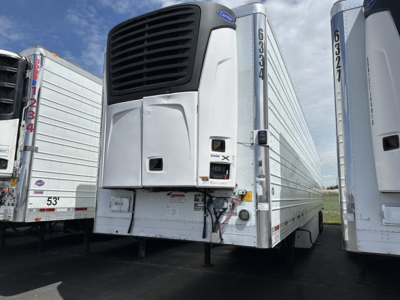 Utility 3000R trailer with reefer unit front view showing vertical refrigeration unit and number 6034 on side; two similar trailers in background.