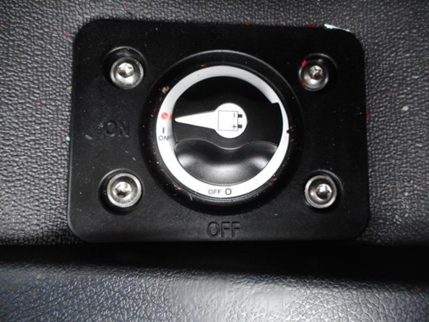 Conventional sleeper truck dash panel with ignition switch showing ON/OFF positions and surrounding screws.