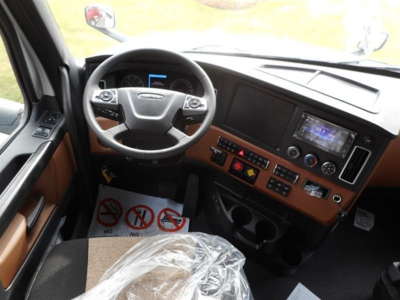 Freightliner Cascadia truck interior dashboard view showing steering wheel and digital display panel.