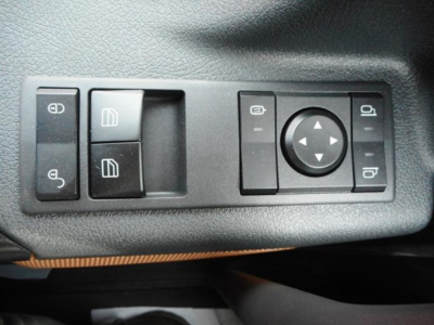 Truck interior switch panel showing window controls and mirror adjustment joystick in a Freightliner Cascadia cab