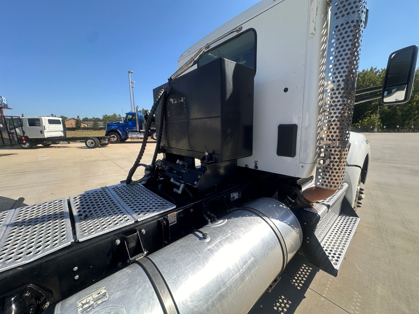 Kenworth T880 daycab exhaust stack and fuel tank area with rear-mounted equipment panel visible.