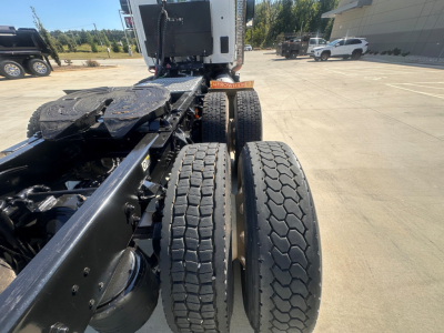 Truck chassis showing two rear dual tires and fifth wheel area of a 2022 Kenworth T880, view from behind cab in an open lot.