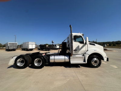 Kenworth T880 conventional daycab tractor side view showing cab, fuel tanks, rear dual axles, and chrome exhaust stack.
