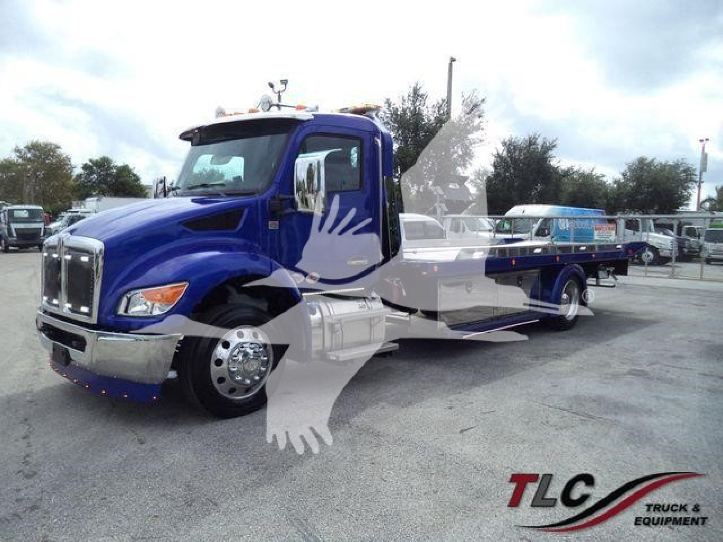 Kenworth T280 rollback truck in blue with chrome grille and side steps, front view showing cab and service bed.