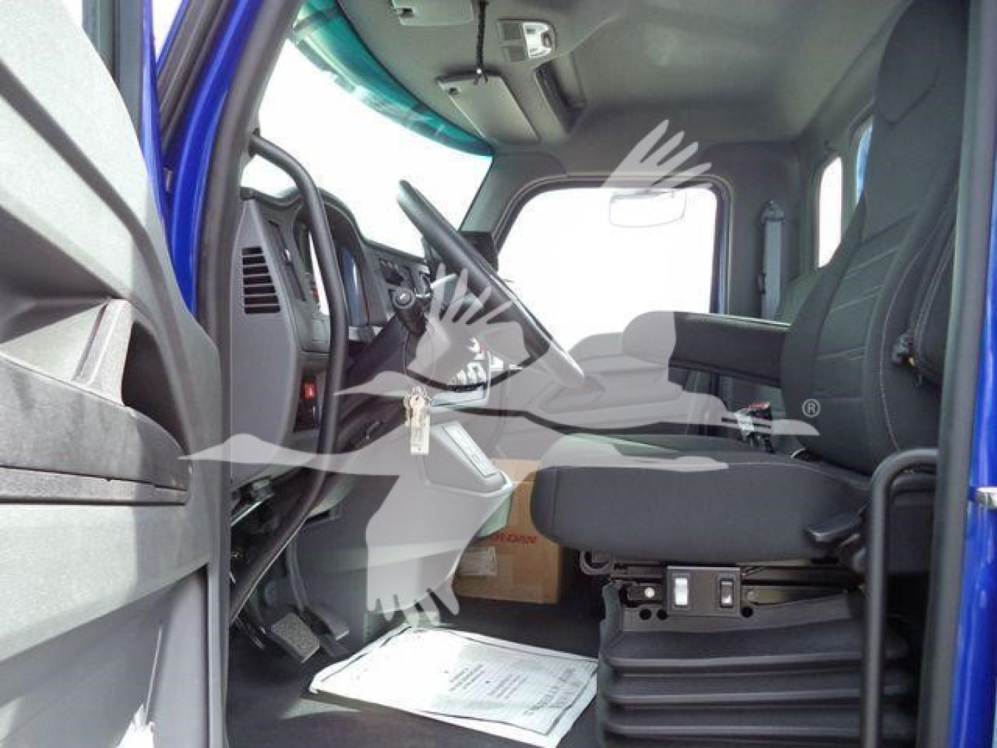 Kenworth T280 cab interior showing driver seat and dashboard area with floor mat and paperwork