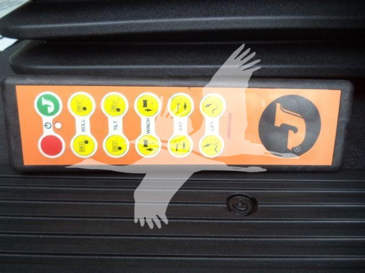 Kenworth T280 front grille with orange control panel showing circular icons and a large circular logo on the right side.