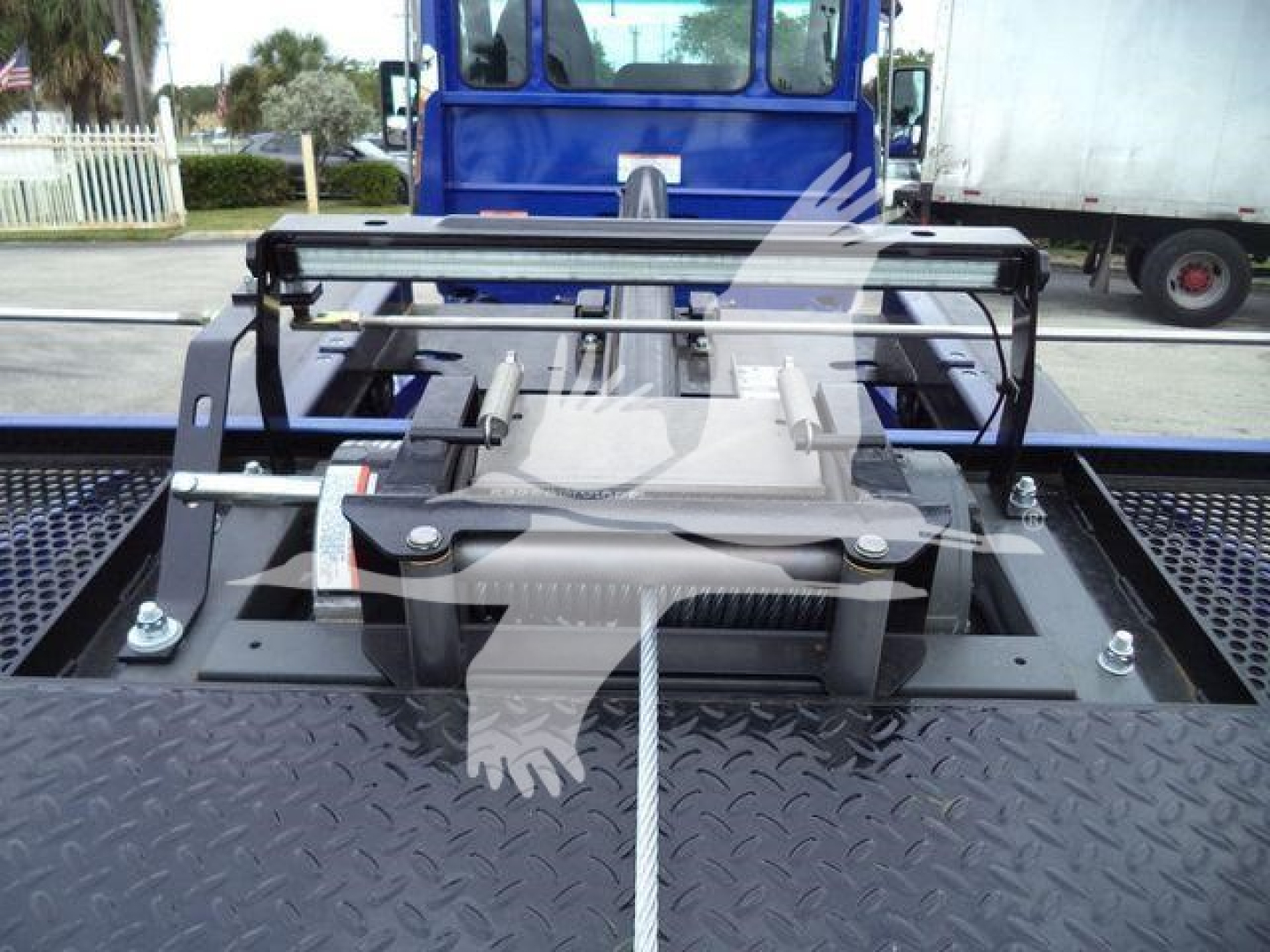 Kenworth T280 rollback truck bed with hydraulic hoist and mounting hardware visible, rear view showing access framework and control components.
