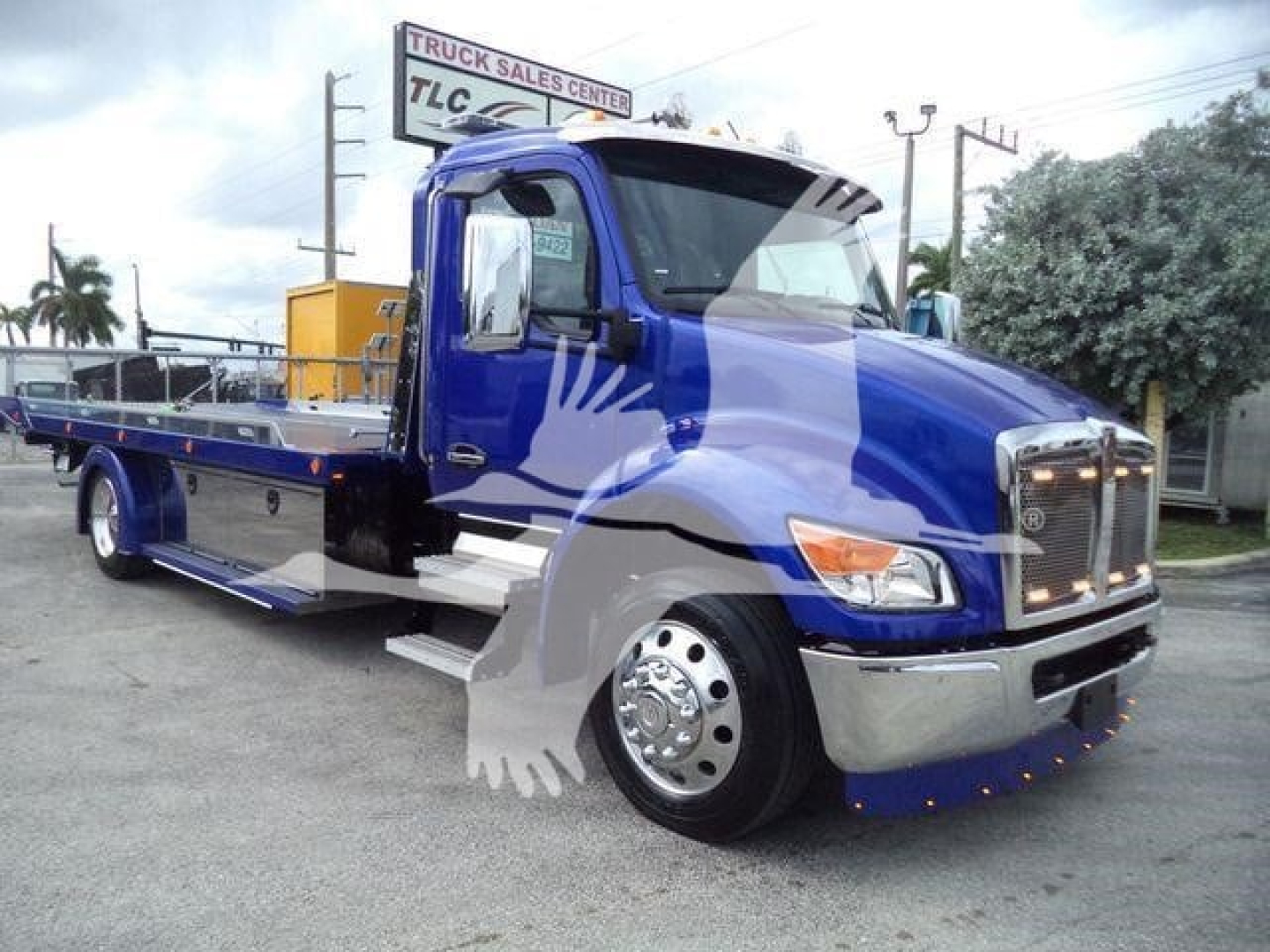 Kenworth T280 rollback truck in blue, side view showing flatbed with chrome wheels and front grille.