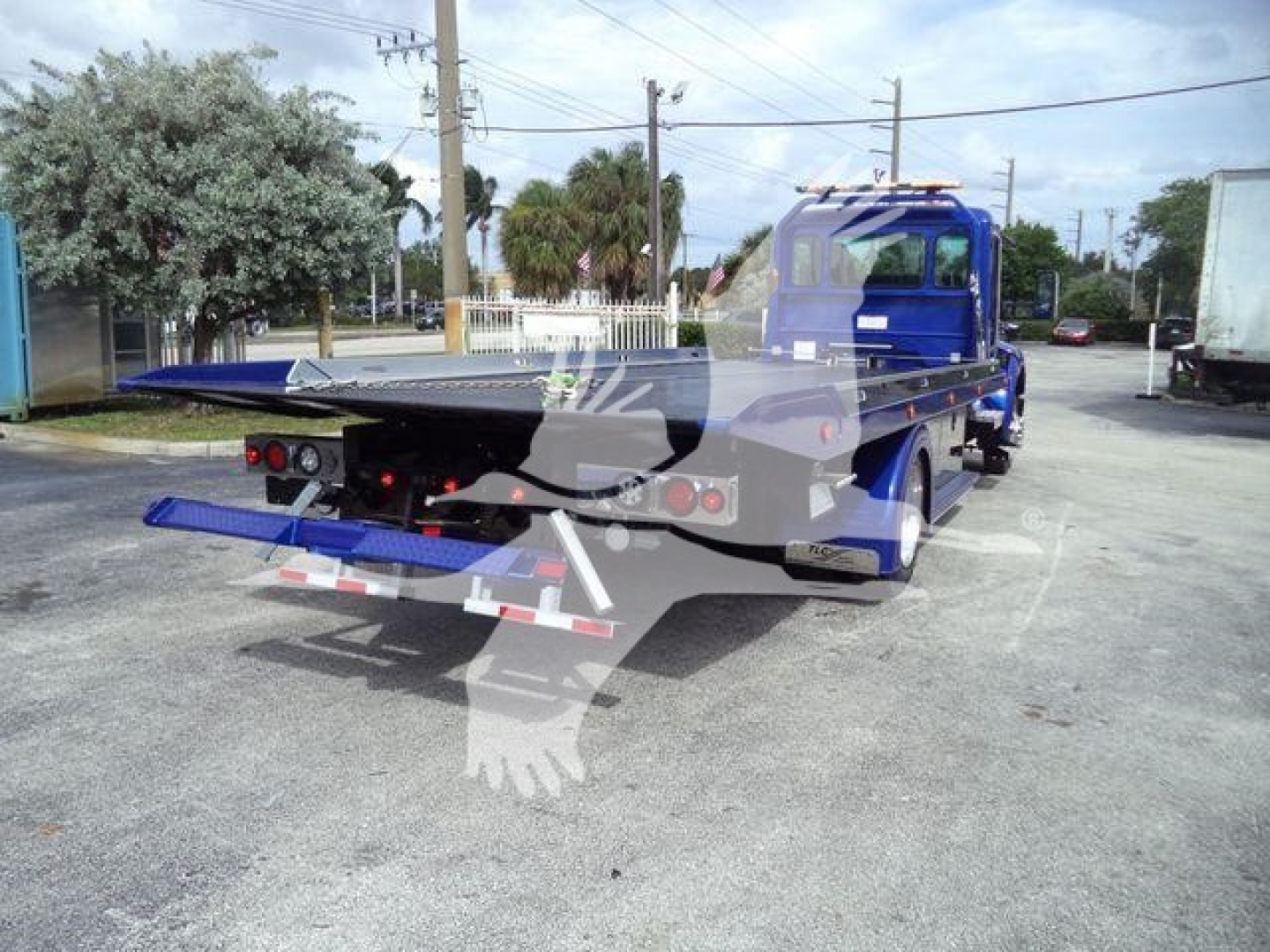 Kenworth T280 rollback truck rear view showing flatbed with extension and blue cab.