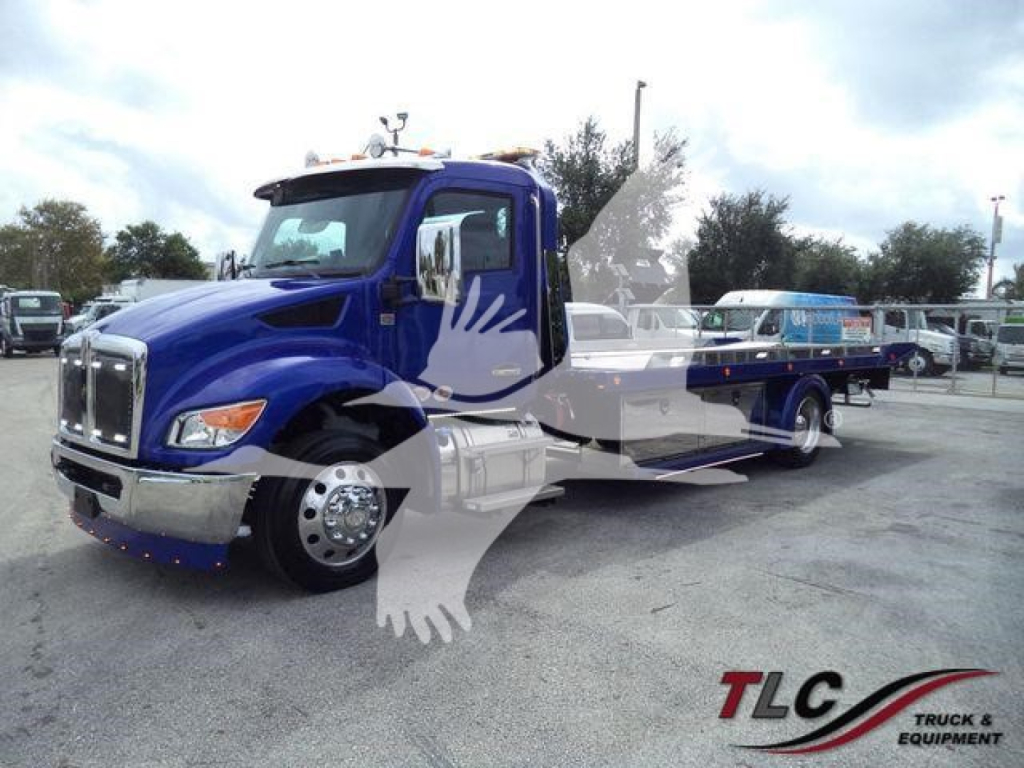 Kenworth T280 rollback truck in blue with chrome grille and side steps, front view showing cab and service bed.