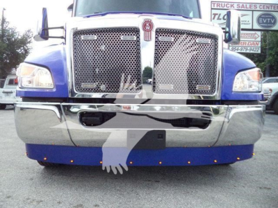 Kenworth T-head front view showing chrome grille, dual large bumper, and blue cab with emblem center; truck in a dealership lot.