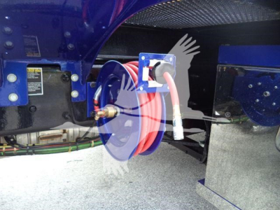 Kenworth T280 rollback truck undercarriage showing external hose reel and hydraulic lines.
