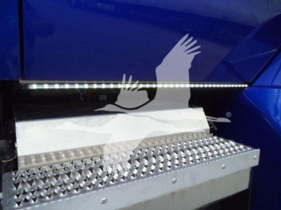 Truck side step with diamond tread and LED strip on a blue Kenworth T280 cab showing metal perforated step and upper light bar.