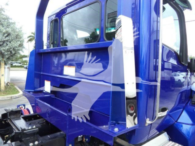 Kenworth T280 rollback truck cab side showing blue paint with white eagle graphic and side step.