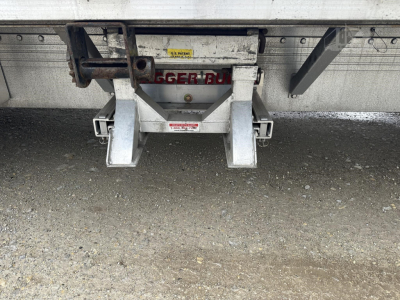 Rear view of a used 2019 Reitnouer Big Bubba drop deck trailer hitch assembly with warning labels and a central latch.