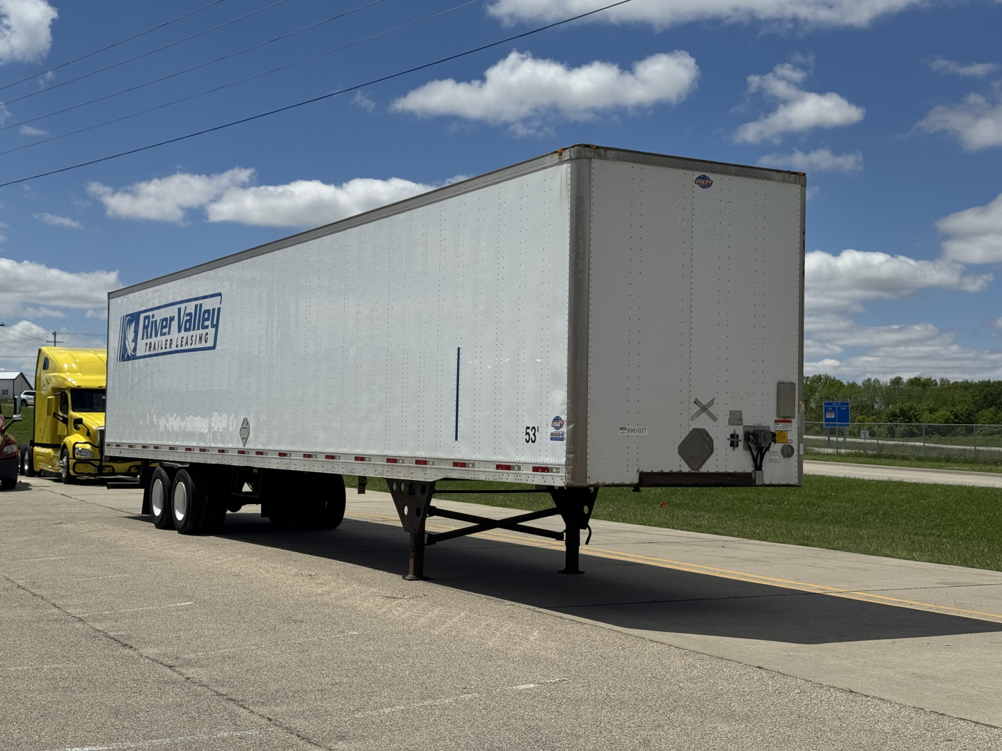 Trailer rear and side view of a River Valley Logistics 2014 Utility 4000D-X trailer with dual rear wheels, white exterior, and company graphic visible.