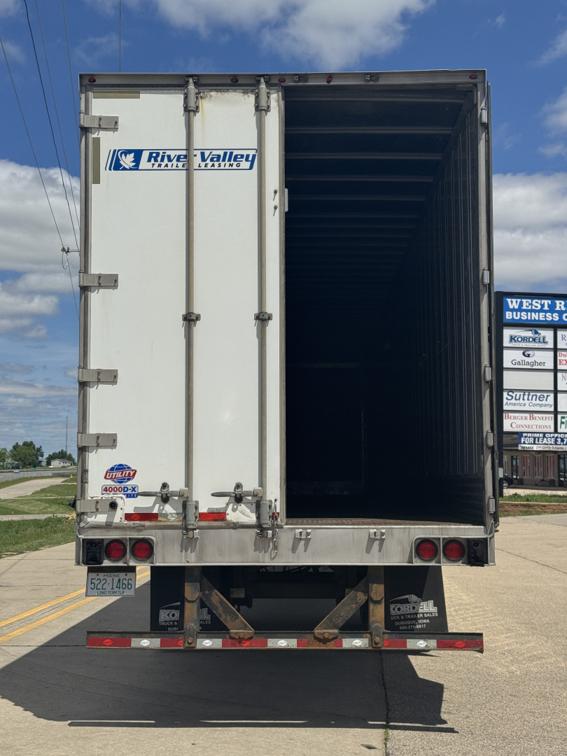 Back of a 2014 Utility 4000D-X trailer with open rear cargo bay, river valley trailer logo, rear lights, and license plate area.