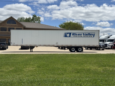 2014 Utility 4000D-X trailer side view with River Valley Trailers Leasing logo, parked on grass in front of building.