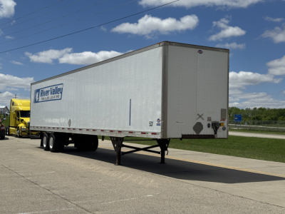 Trailer rear and side view of a River Valley Logistics 2014 Utility 4000D-X trailer with dual rear wheels, white exterior, and company graphic visible.