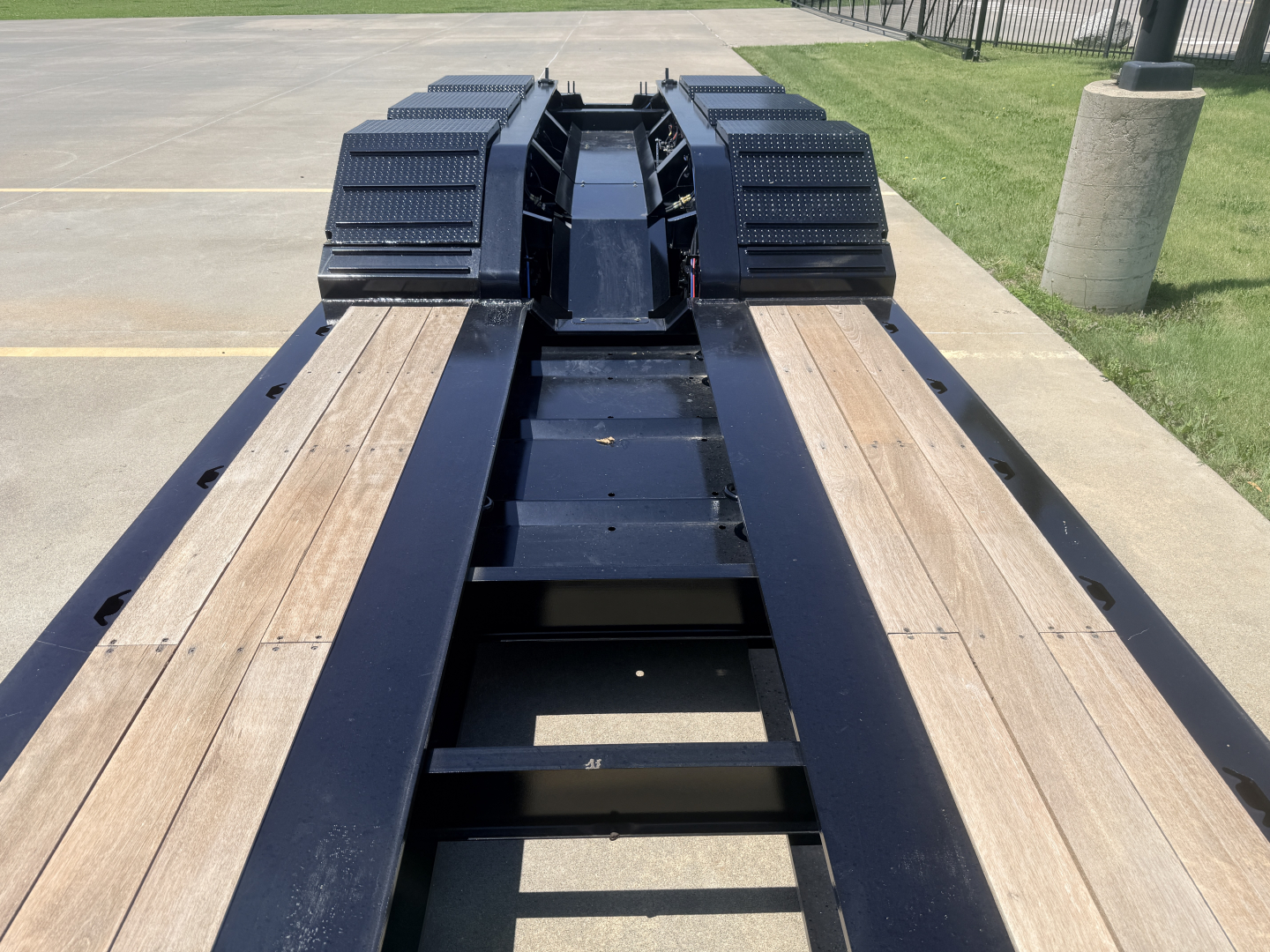 Trailer deck with LDH gooseneck lighting and wood planks, black frame, heavy-duty wheels in background; Alpha A110HDG-SF-18" LDH sign branding not visible.