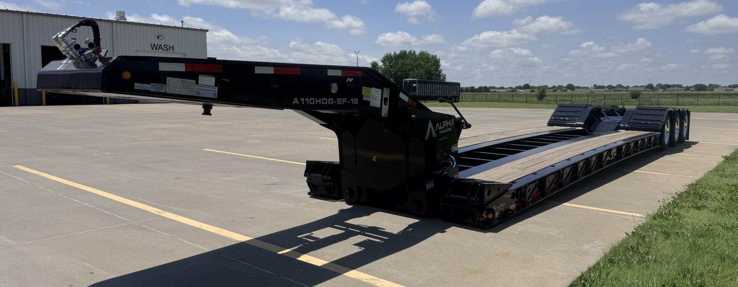 Lowboy trailer shows A110HDG-SF-18" LDH designation on foldable gooseneck, long black deck with dual axles, parked on asphalt.