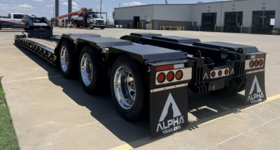 Alpha Trailers lowboy trailer rear view showing dual rear axles, black diamond plate bed, mud flaps with Alpha Trailers logo, and rear lights.