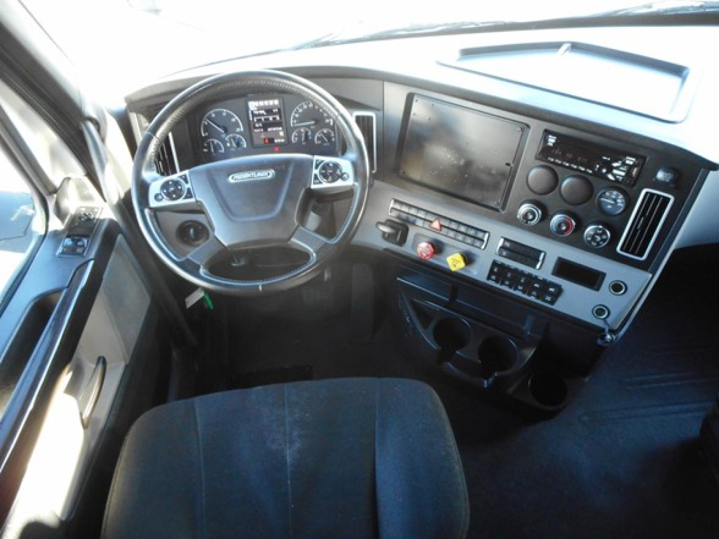 Freightliner Cascadia 126 dash and steering wheel showing instrument cluster and center touchscreen display.