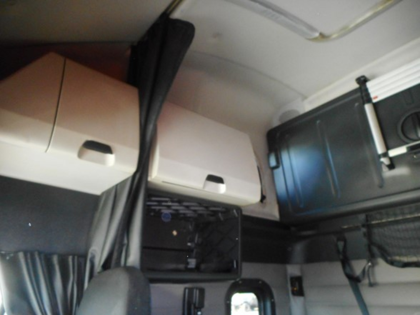 Freightliner Cascadia 126 interior/driver area showing overhead sleeper cabinets and storage pockets with a small open compartment.