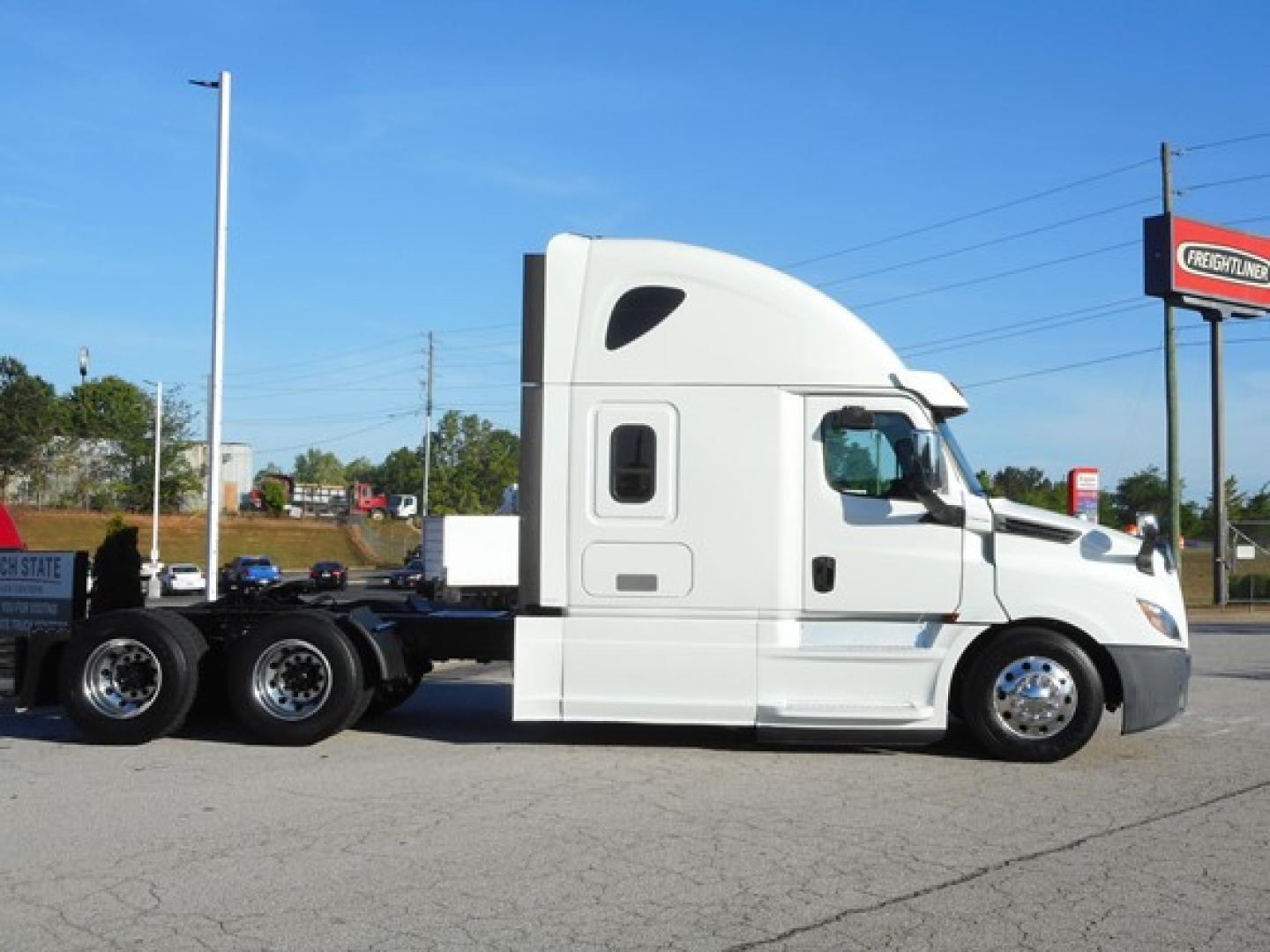 2019 Freightliner Cascadia 126 tractor truck in side profile view, white exterior, sleeper cab, with five visible wheels and attached trailer chassis.