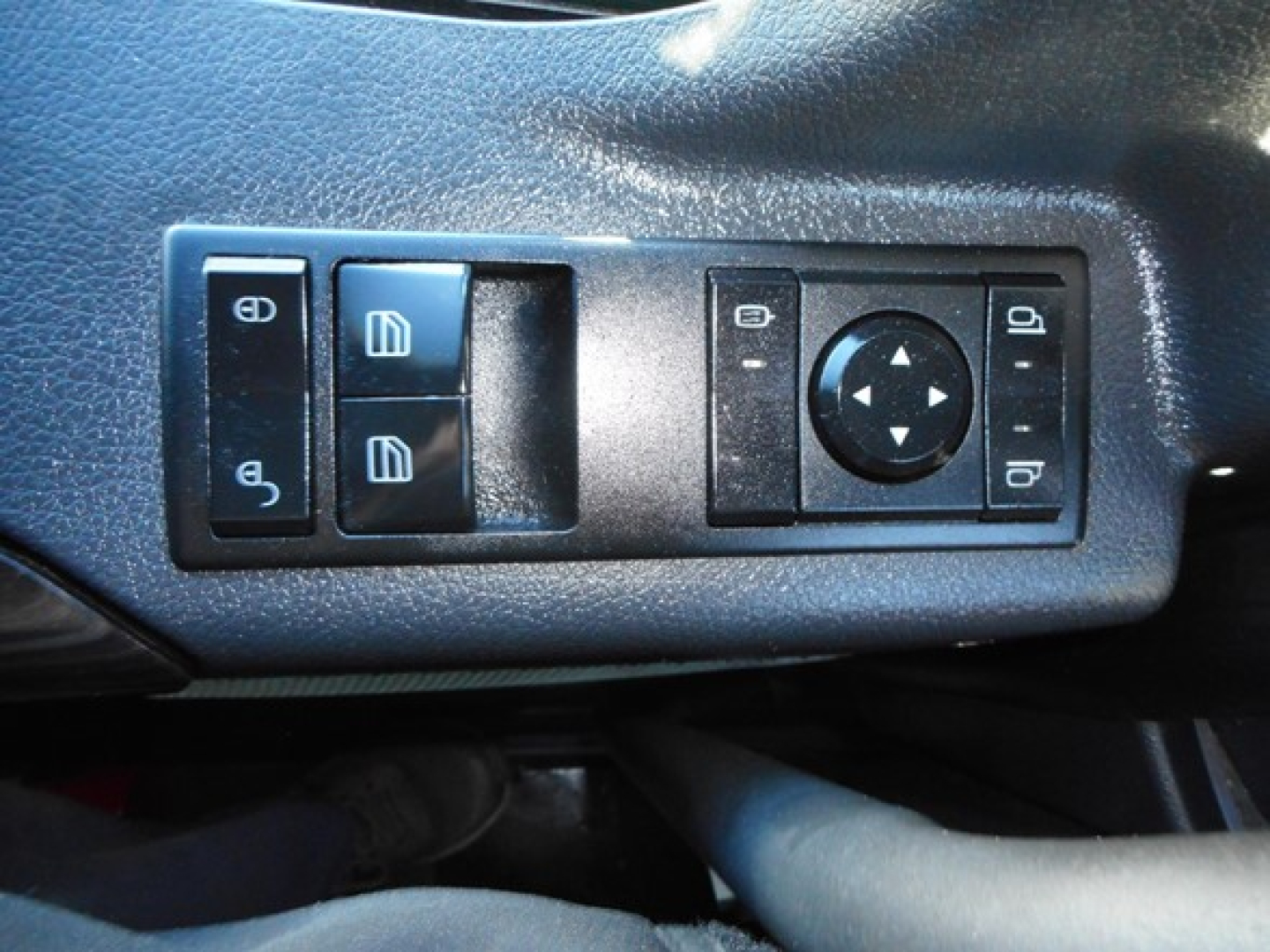 Cascadia truck interior control panel photo showing window/lock switches and joystick-like directional pad on door armrest