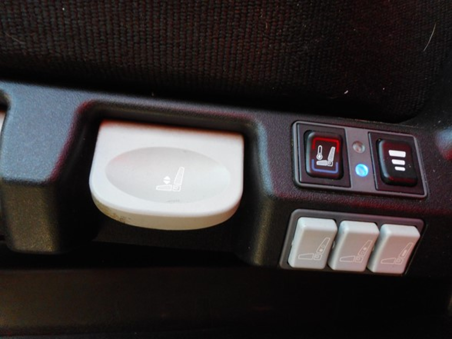 Seat controls on Freightliner Cascadia dash with heated seat switch and three window/seat adjustment buttons.
