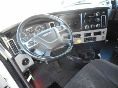 Freightliner Cascadia truck interior showing steering wheel and dashboard with gauges and controls.