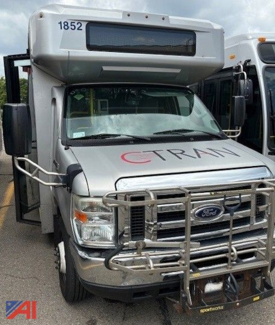 Ford E450 shuttle bus front view with bull bar guard and raised roof, CT RAM logo on hood, number 1852 on top left, side mirror racks visible.