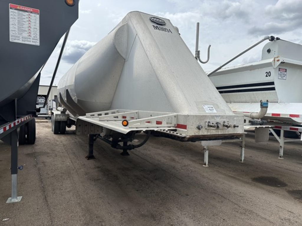 Pneumatic dry bulk trailer with 2019 Mac 1050 cu ft capacity, front angle showing rounded tank and frame, VIN 150120525741, stock UE11731.