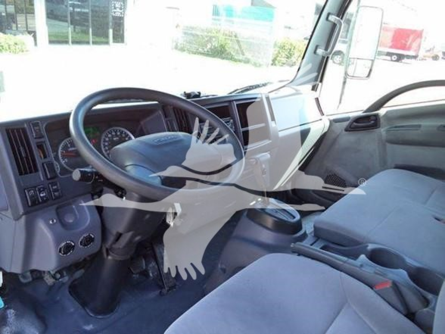 Isuzu NPR/NRR truck cab interior showing steering wheel and dashboard with gauges and controls.
