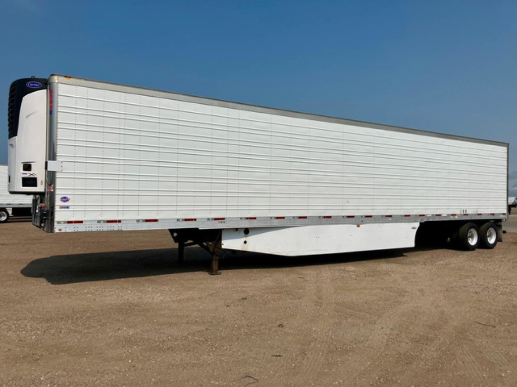Utility reefer trailer side view showing refrigerated box with white siding and underside wheel area.