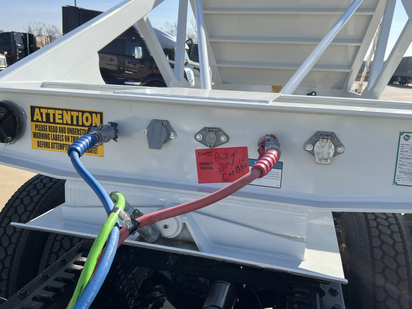 Armor Lite SBD42 tri-axle air ride trailer hitch area with colored hoses, warning labels, and铭 engraving visible on rear frame