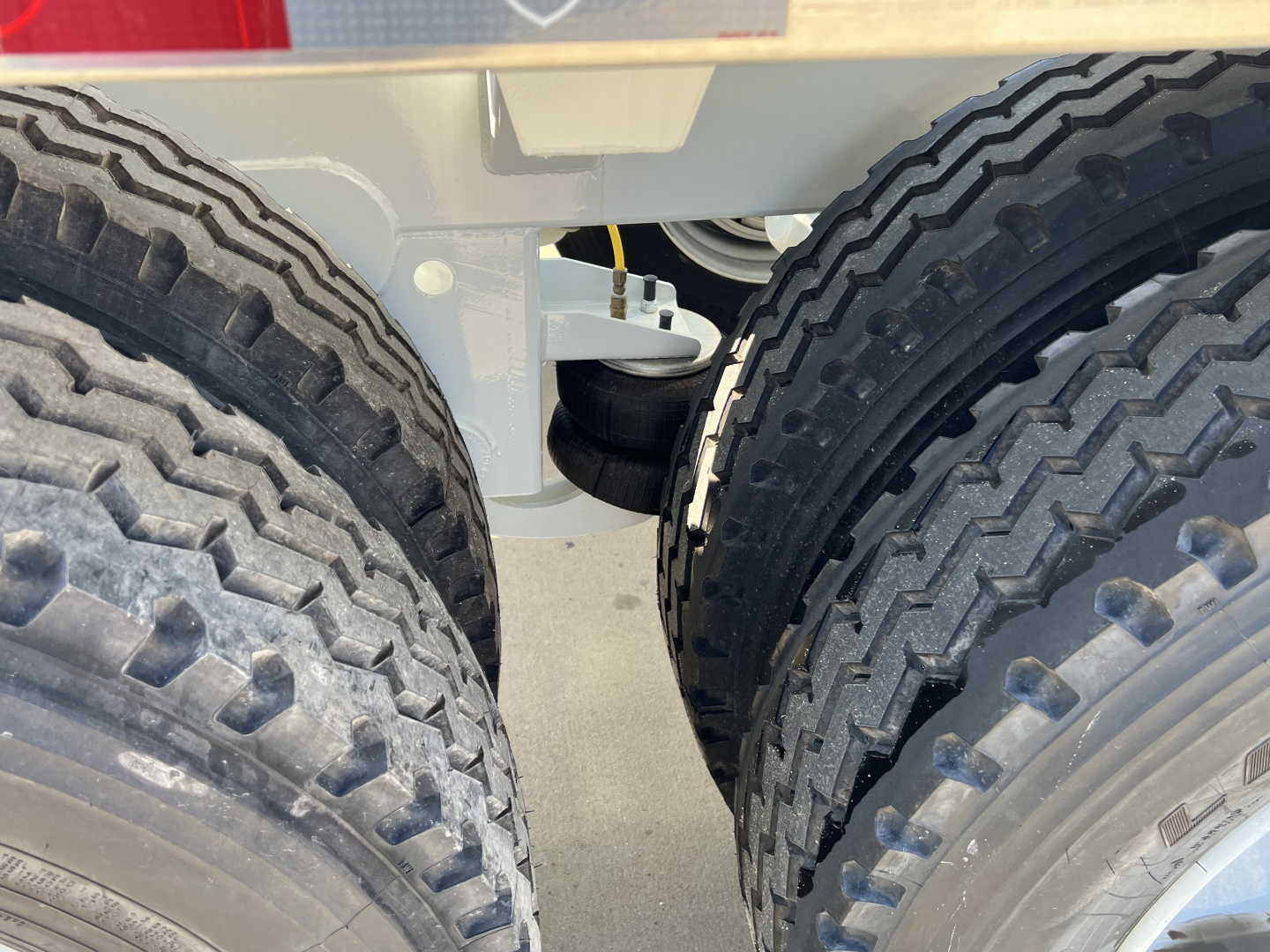 Rear view of Armor Lite SBD42 tri-axle air ride trailer showing dual rear tandem tires and suspension components.