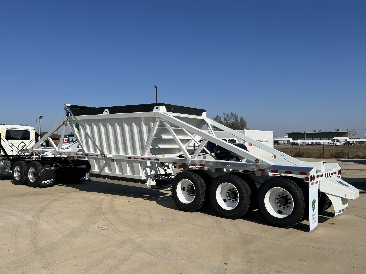 Armor Lite SBD42 tri-axle air ride trailer in white showing Skeletal framework and triple-axle suspension with deck, side rails, and tail section.