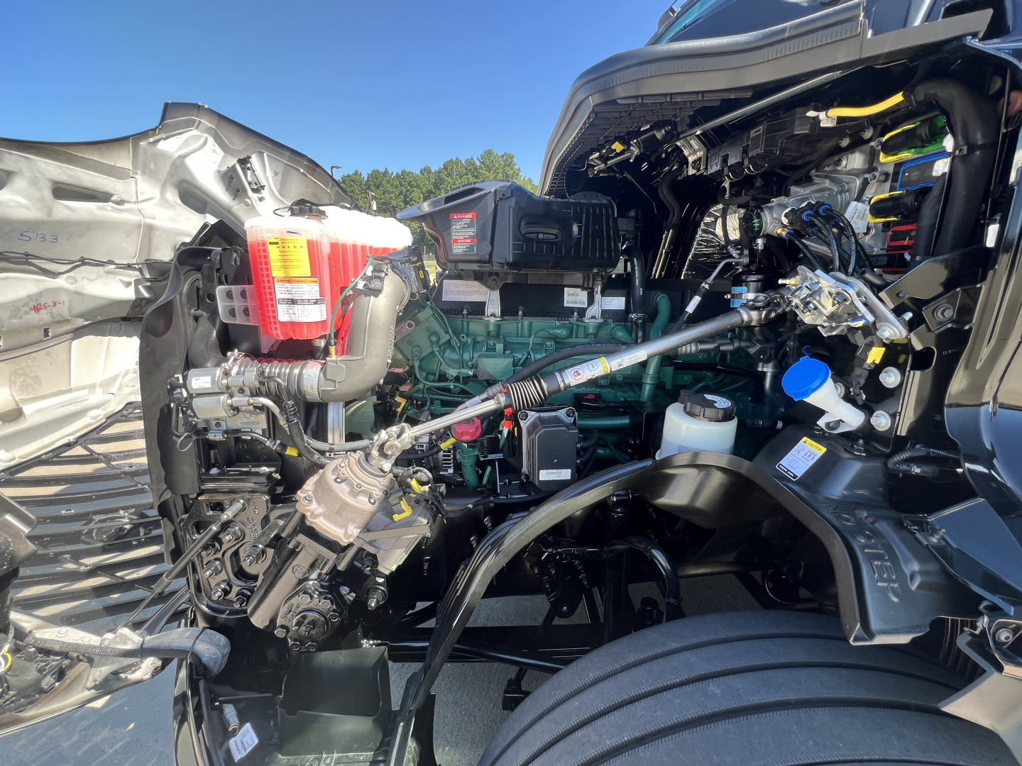 Engine bay of a Volvo VNL64T840 conventional sleeper showing diesel engine, fuel filters, hoses, and electrical components.