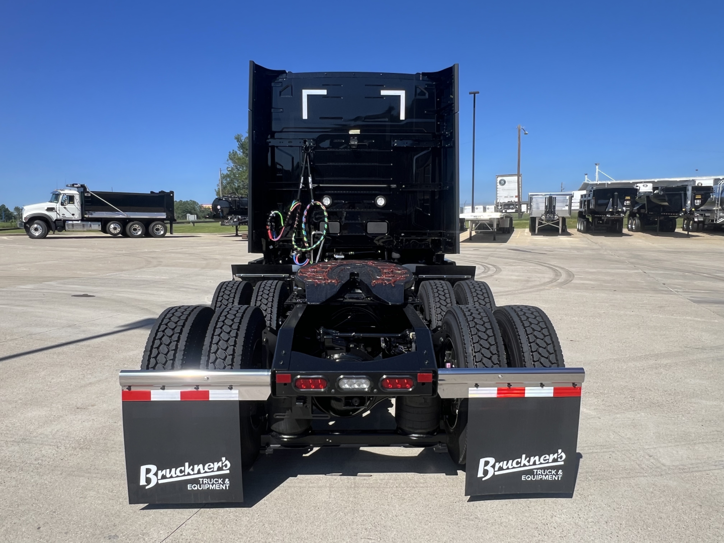 Volvo VNL64T840 truck rear view showing dual rear axles and mud flaps with Buckner's Equipment branding.