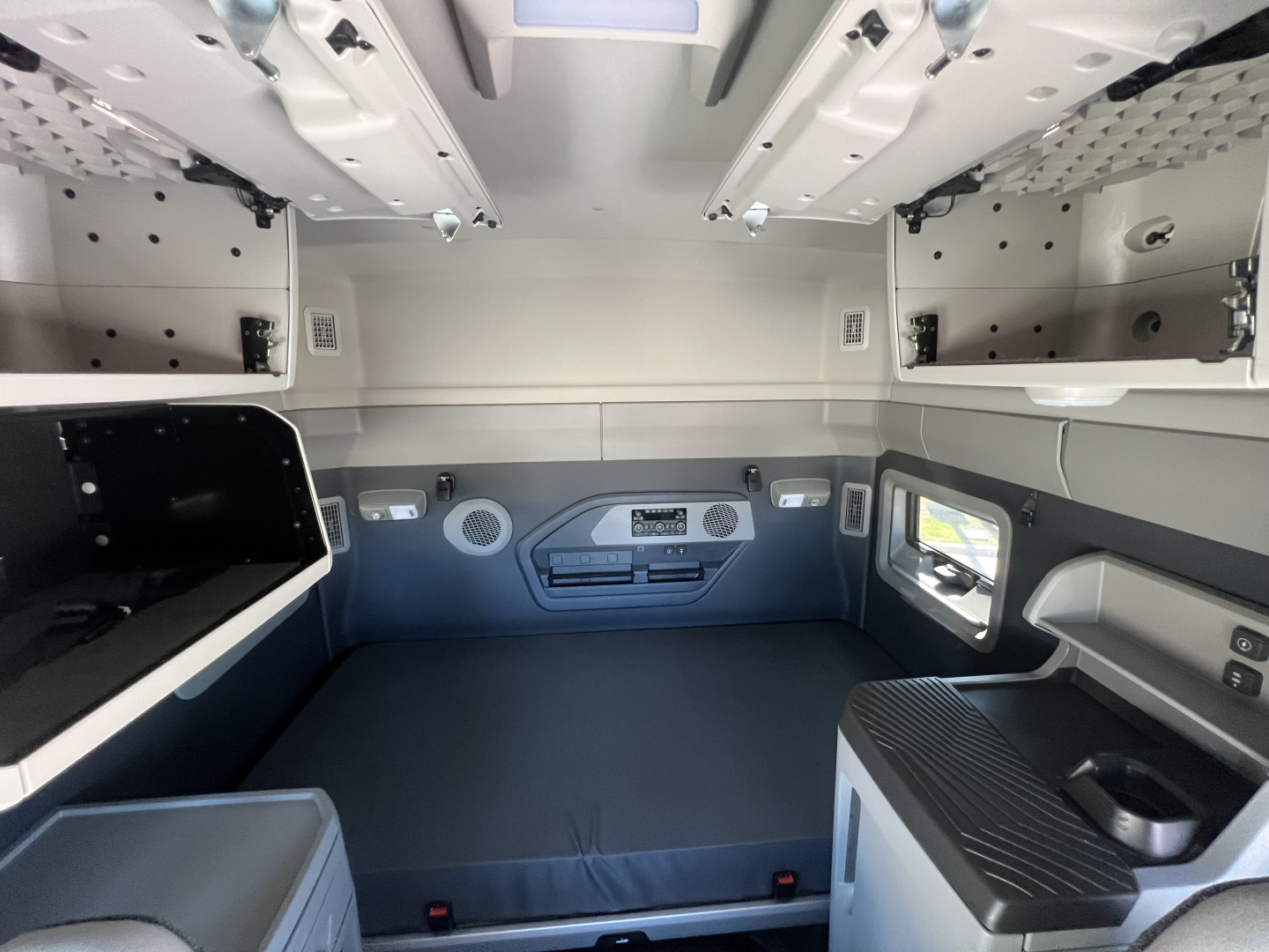 Volvo VNL64T840 sleeper cab interior showing bunk area with storage cabinets and control panels.