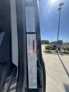 Vehicle door jamb label with VIN and basic specs for a Volvo VNL truck. Visible text includes VIN, possibly stock number, and compliance/label blocks.
