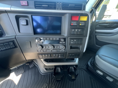 Volvo VNL64T840 truck cockpit showing center dash with touchscreen, climate controls, and storage pedals.