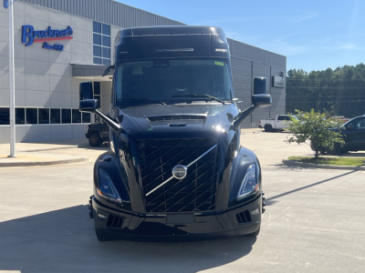 Front view of a black Volvo VNL64T840 tractor with prominent grille and headlamps in a dealership lot.