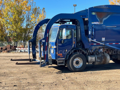 Peterbilt 520 garbage truck in blue with rear compactor and articulated lift arms, side view of cab, VIN 3BPDLJ0X7MF110420 visible on image.