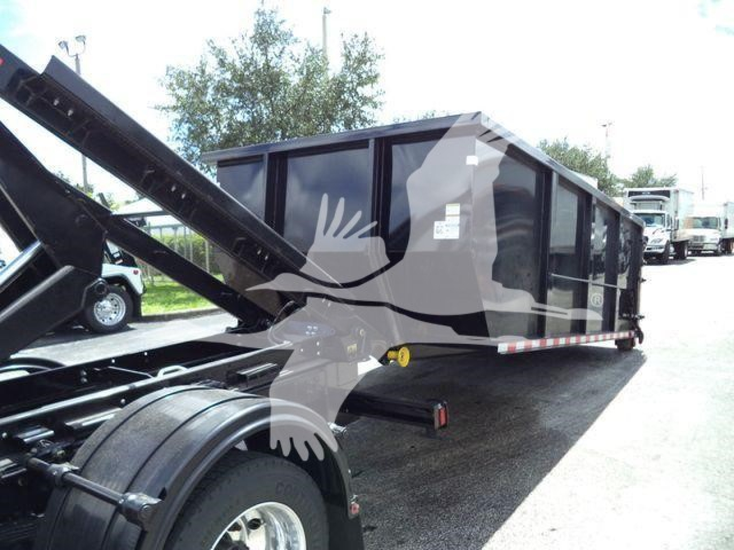 Truck bed with roll-off trailer and container on a Chevrolet Silverado 6500HD chassis showing side panels and hydraulic arm in operation.